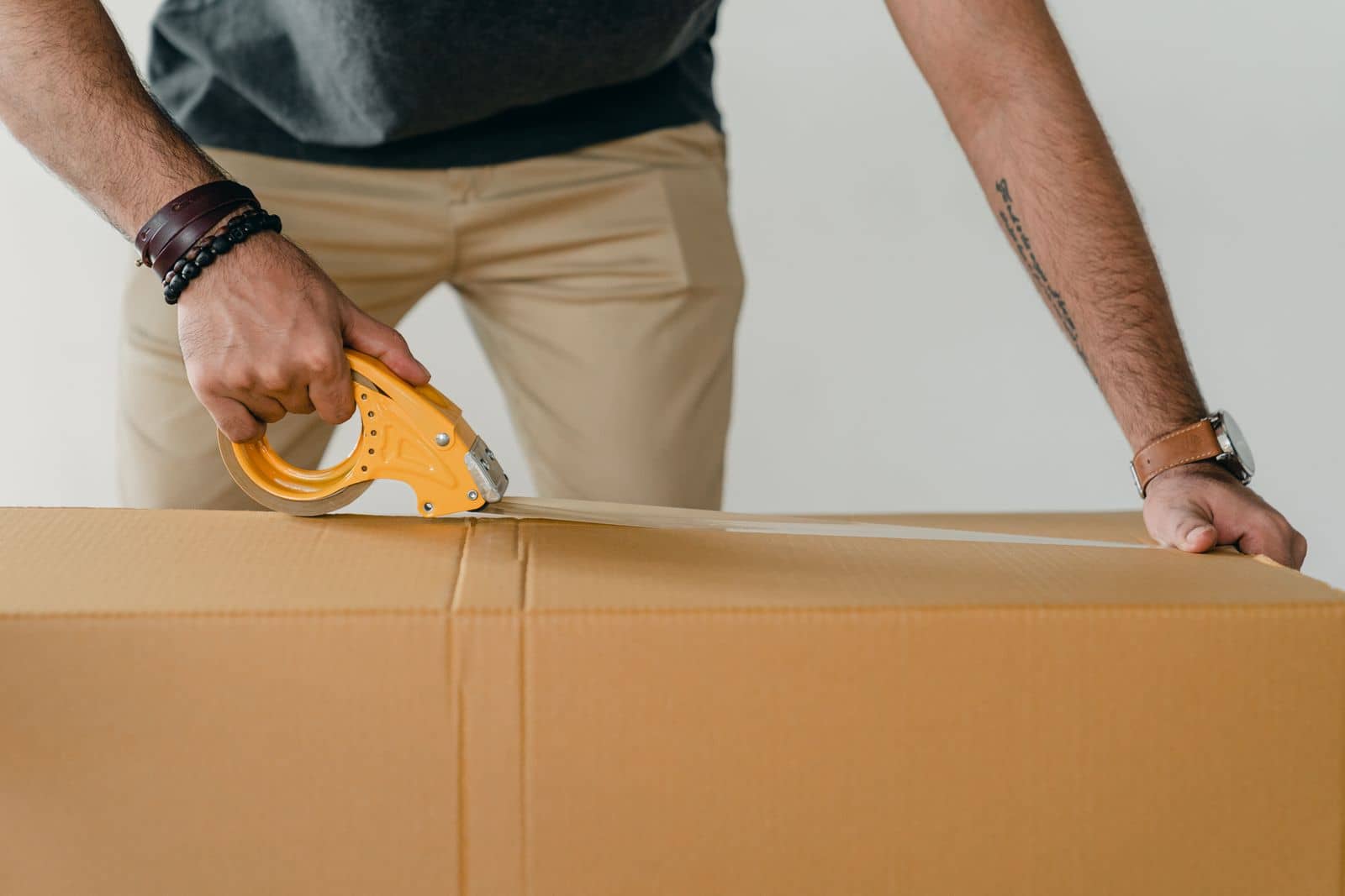 A carton being sealed with packing tape